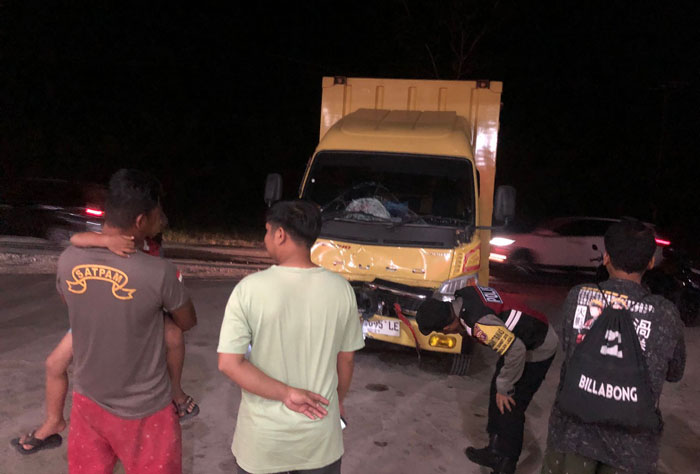 KECELAKAAN: Truk yang mengalami kecelakaan di ruas Jalan Ahmad Yani, Kecamatan Pangkalan Lada, serta korban pengendara roda dua yang mengalami luka berat, Kamis (6/2) malam.