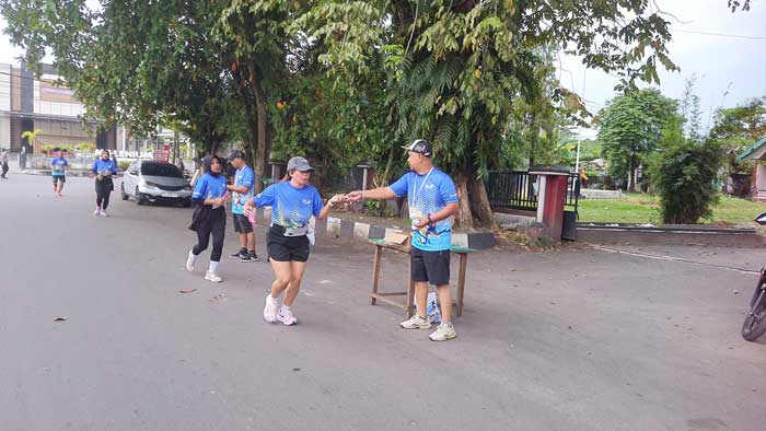 TERUS BERLARI: Peserta Radar Sampit Fun Run saat di check point, menerima pita dan suplemen kesehatan yang disediakan panitia. HENY/RADAR SAMPIT