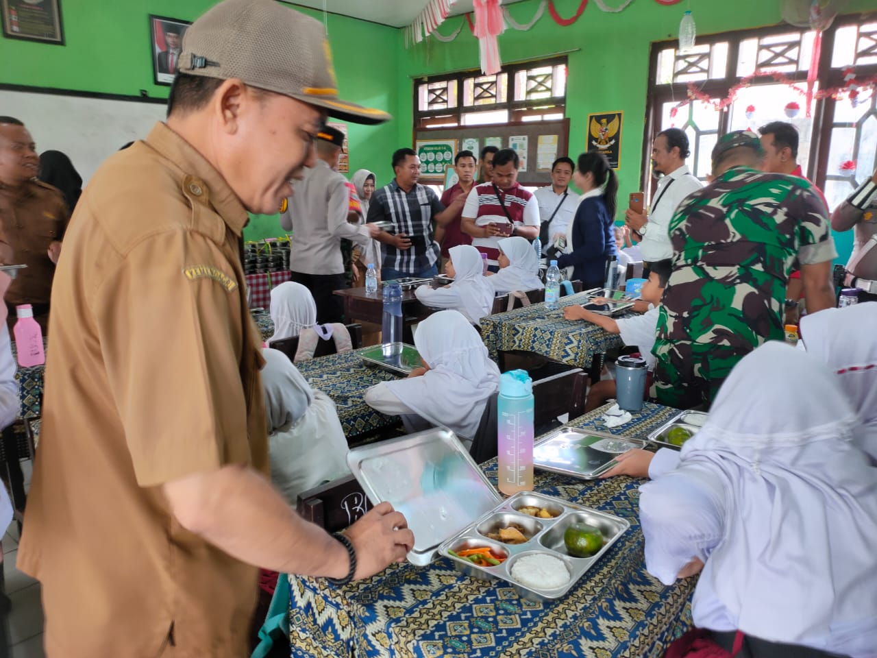 Kepala Dinas Pendidikan Kotim Muhammad Irfansyah saat membagikan makanan kepada siswa SDN 1 Sawahan, Senin (24/2).&nbsp;YUNI/RADAR SAMPIT