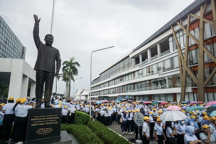 PHK MASSAL: Buruh dan karyawan keluar pabrik melintas di samping patung pendiri Sritex HM Lukminto di Pabrik Sri Rejeki Isman Tbk (Sritex) di Sukoharjo, Jawa Tengah, Jumat (28/2).
