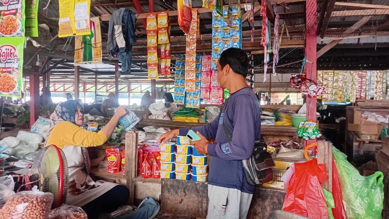 KABAR PASAR: Jamilah, pedagang di Pasar Saik, Kuala Pembuang sedang melayani pembeli. M. RIFANI DEWANTARA/RADAR SAMPIT