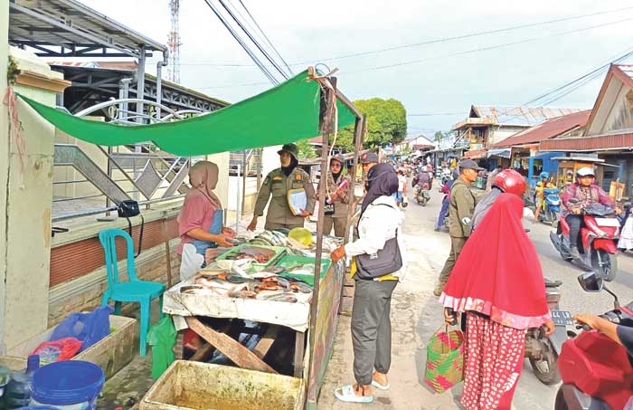 TEGURAN: Anggota Satpol PP Kotim saat memberikan surat teguran ke pedagang di Jalan Sukabumi, Kamis (6/3).&nbsp;IST/RADAR SAMPIT