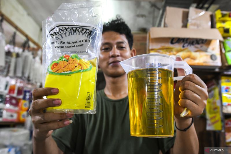Pedagang menunjukkan volume Minyakita yang sesuai takaran di Pasar Tebet Barat, Jakarta, Selasa (11/3/2025). Kementerian Perdagangan mulai menarik produk minyak goreng bersubsidi merek Minyakita