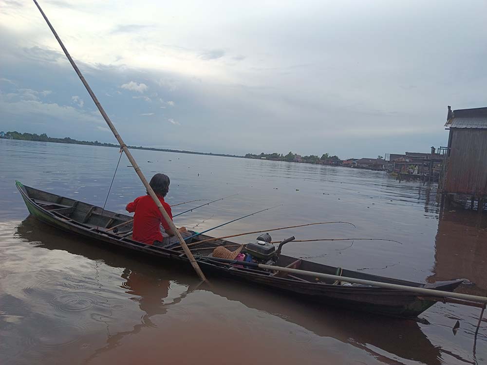 MENANTI BUKA PUASA: Warga&nbsp; Kuala Kapuas yang memancing di Sungai Kapuas, Rabu (12/3/2025).&nbsp;SABRI/RADAR SAMPIT