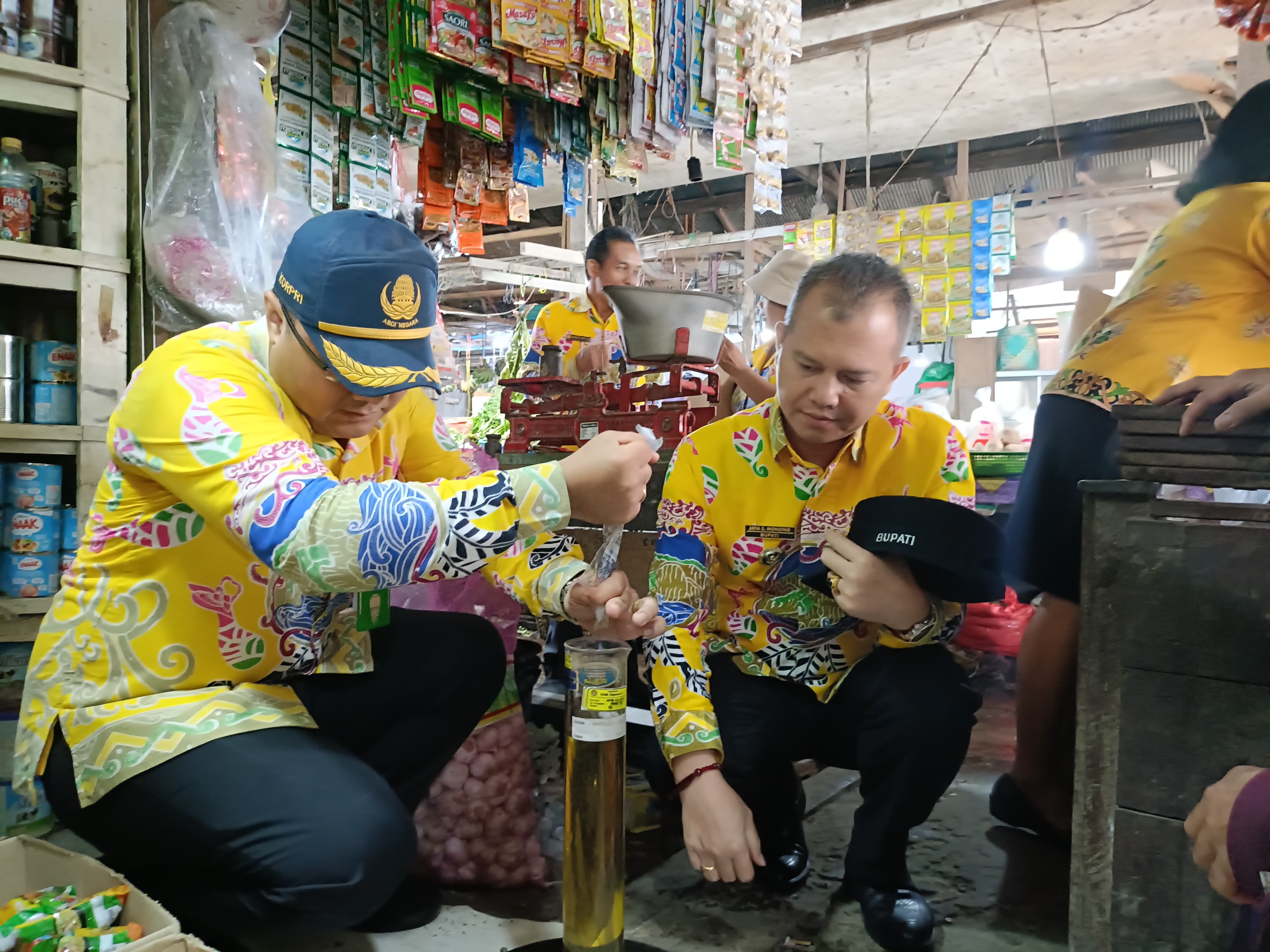 UKUR ISI MINYAK: Bupati Gumas Jaya Samaya Monong bersama Kapolres AKBP Theodorus Priyo Santosa, Kajari Sugito, ketika mengukur takaran minyak goreng, yang dijual pedagang di Pasar Lama Kuala Kurun