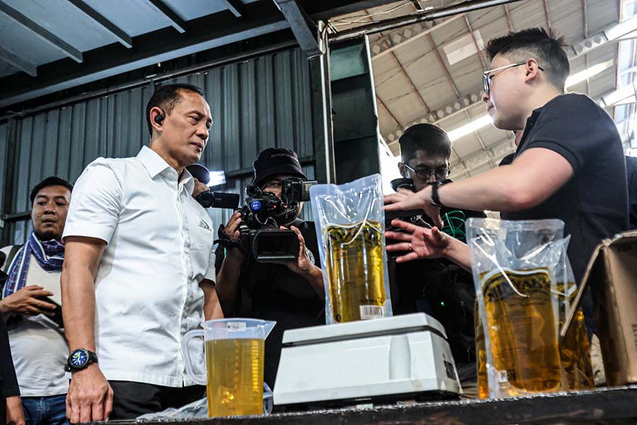 Kasatgas Pangan Polri Brigjen Helfi Assegaf  (kiri) melakukan penimbangan saat sidak di pabrik pengepakan Minyakkita di Batuceper, Kota Tangerang, Rabu (12/03/2025). Sidak tersebut dilakukan untuk menindaklanjuti maraknya peredaran Minyakkita yang tidak s