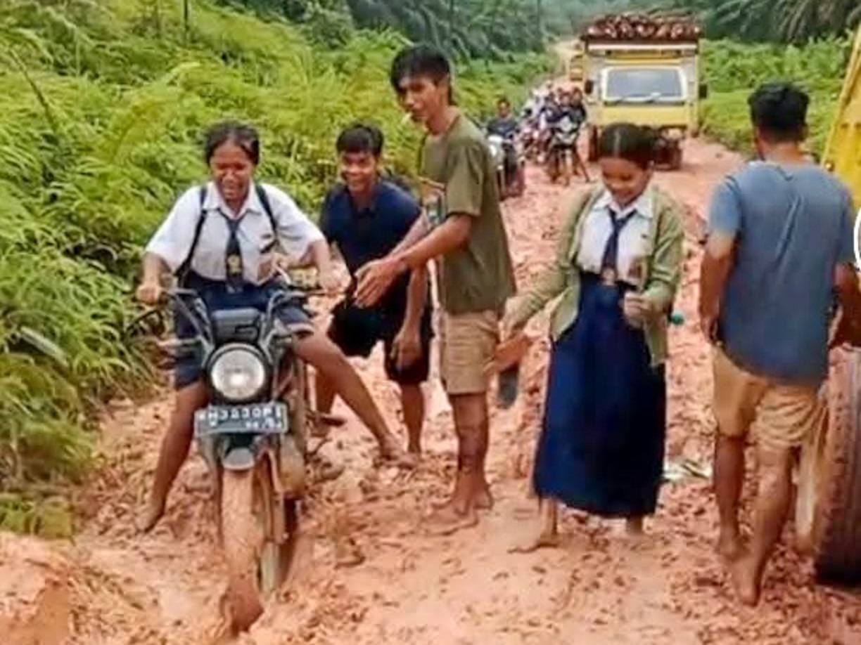 BERJIBAKU: Sejumlah warga dan pelajar di wilayah hulu Kabupaten Seruyan, yang terpaksa melalui jalan berlumpur.