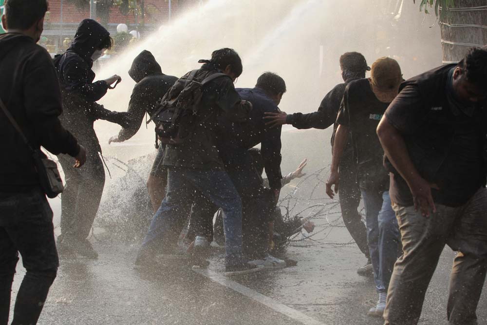 UNJUK RASA: Polisi menyemprotkan air dari water canon untuk menghalau sejumlah pengunjuk rasa yang beraksi untuk menyikapi UU TNI di Surabaya, Jawa Timur, Senin (24/3/2025).ANTARA FOTO/Didik Suhartono