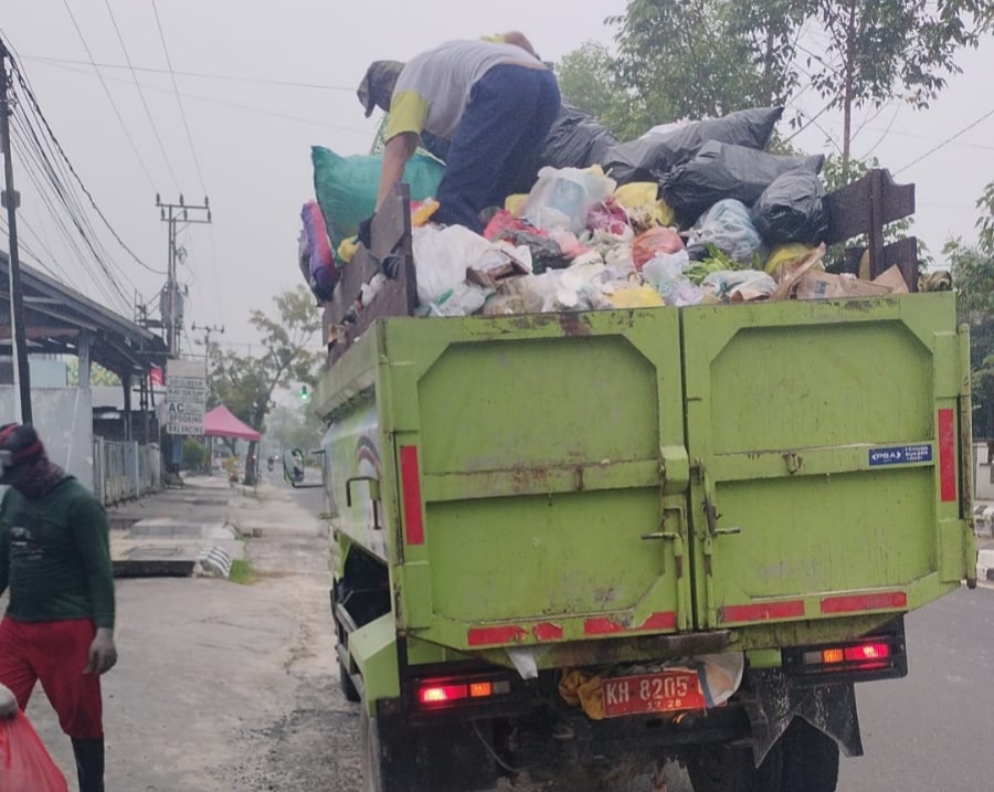 KERJA KERAS: Petugas kebersihan saat mengangkut sampah di sejumlah ruas jalan di Kota Pangkalan Bun belum lama tadi.