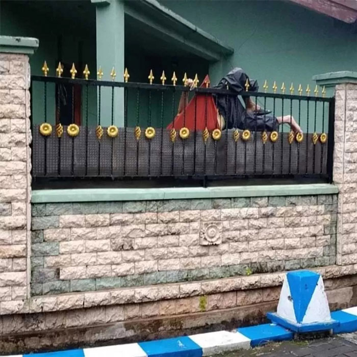 MENINGGAL: Kondisi korban saat tersangkut pagar di Perum Sidokare Indah, Sidoarjo, Kamis (3/4). (Foto: Radar Sidoarjo)