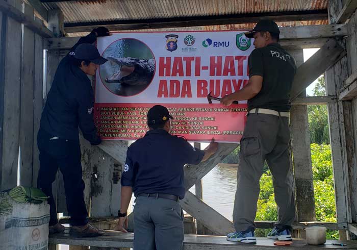PENCEGAHAN: Pemasangan spanduk peringatan di salah satu titik rawan serangan buaya.