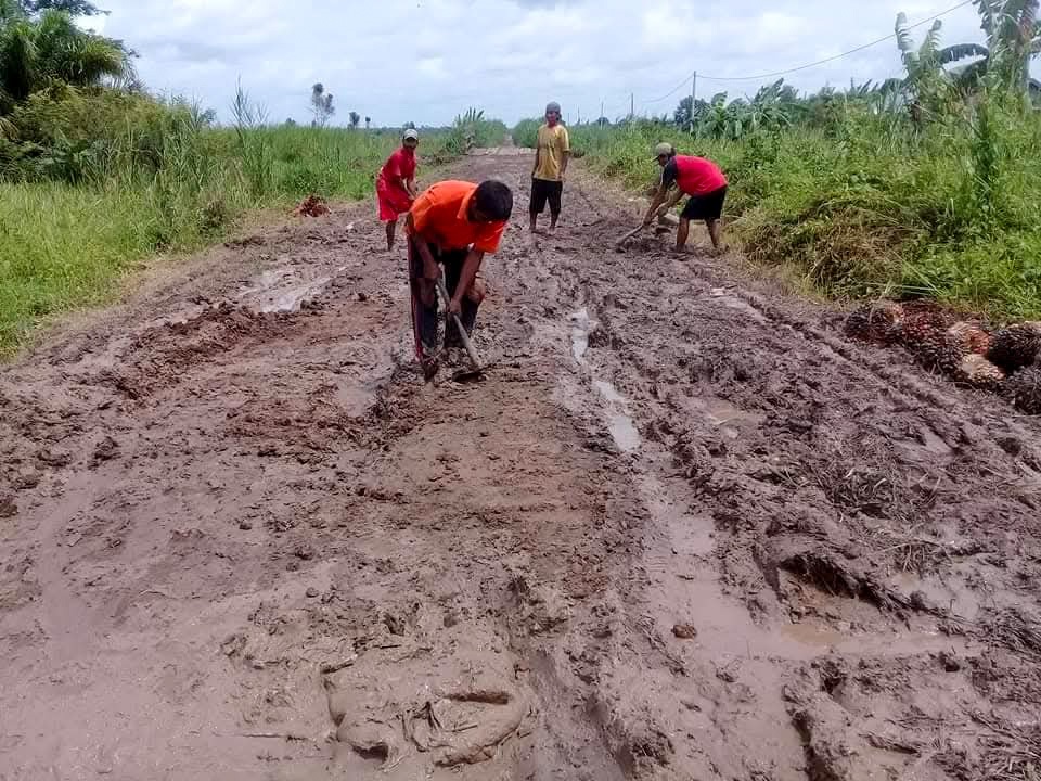 PERBAIKAN: Masyarakat sekitar berjibaku memperbaiki jalan poros Trans Unit 5 yang masih rusak.