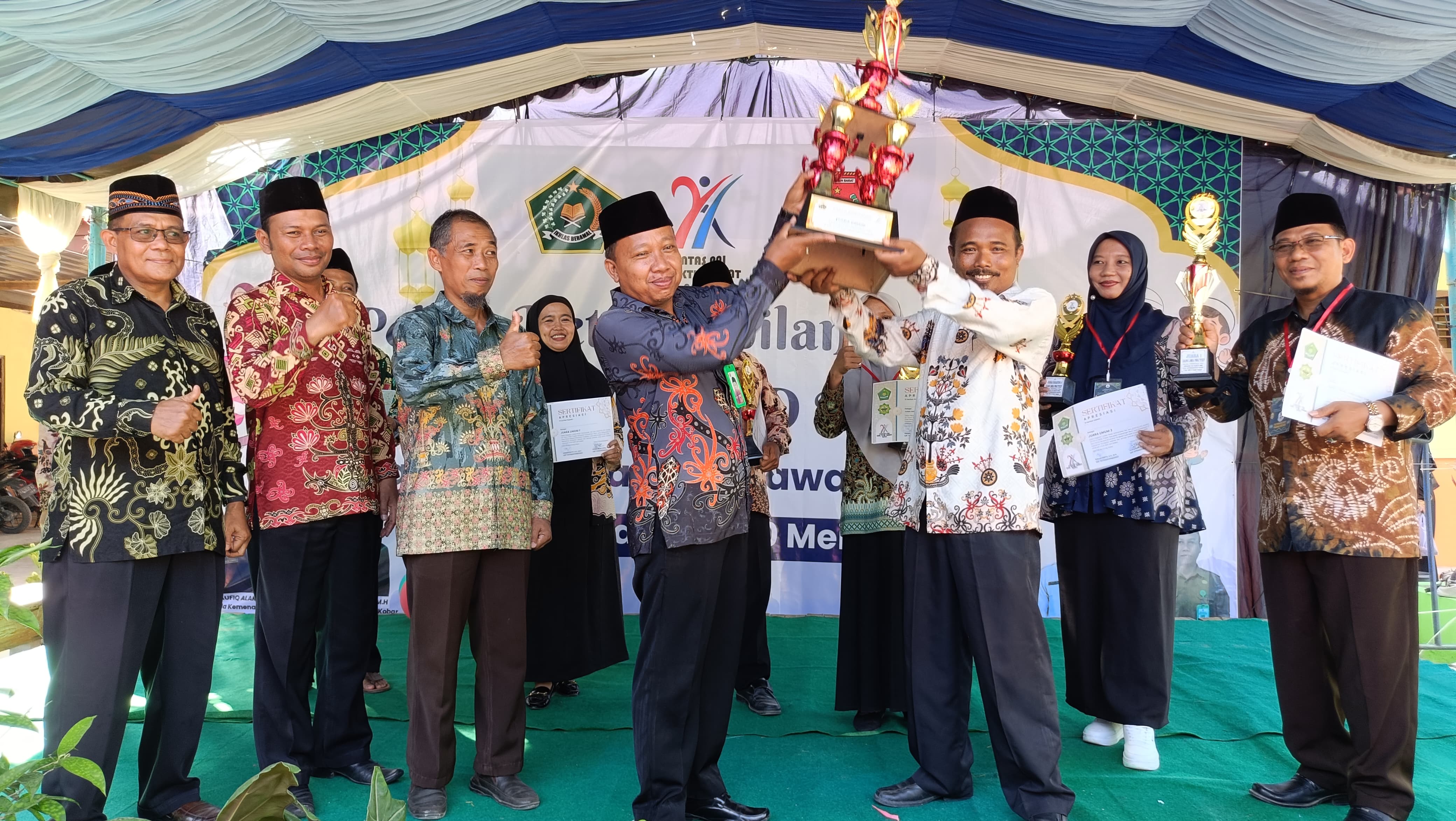JUARA: Ketua KKG PAI Kecamatan Pangkalan Banteng, Nooralim (kanan) saat menerima trofi juara umum dari Kasi PAI Widaryanto. (Huda for Radar Sampit)