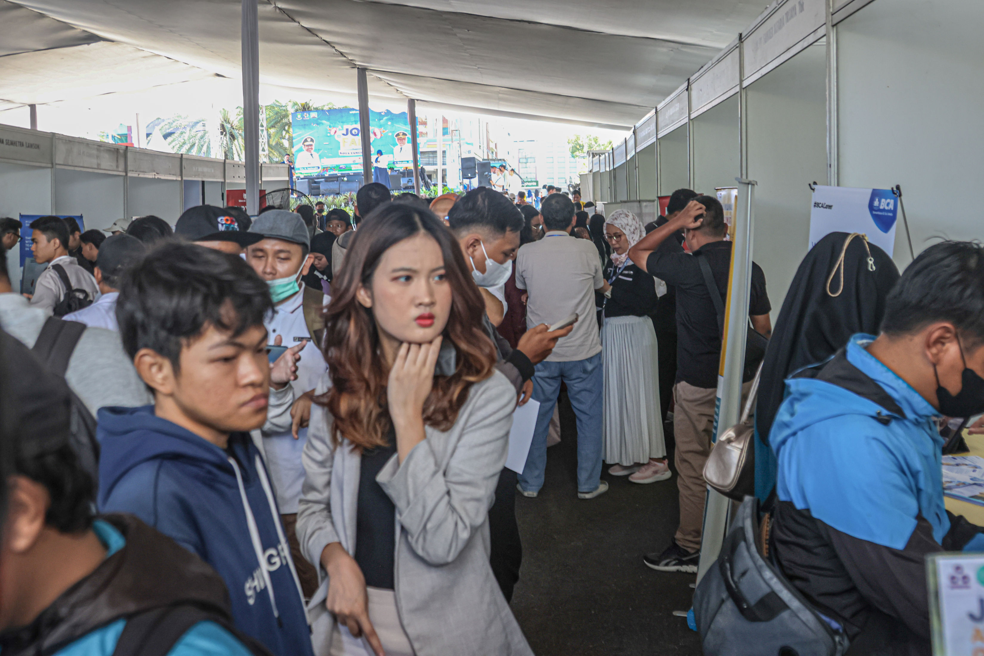 Sejumlah pencari kerja melihat lowongan pekerjaan di Job Fair di Kota Tangerang, Rabu (23/04/2025). Pemerintah Kota Tangerang membuka 8897 lowongan pekerjaan dengan menghadirkan 50 perusahaan di acara tersebut. HANUNG HAMBARA/JAWA POS