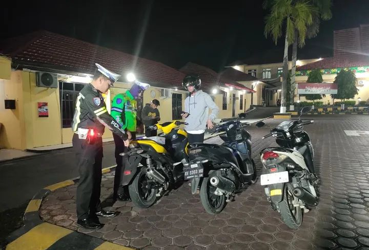 Anggota kepolisian menahan kendaraan berknalpot brong, Sabtu (31/5) pukul 23.25 WIB.
