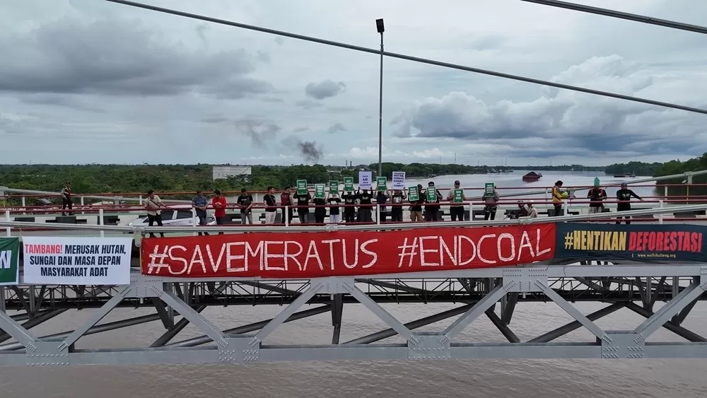 PROTES: Para aktivis Walhi dari Kalimantan Selatan dan Tengah menggelar aksi protes di Jembatan Barito, Ahad (1/6). (Walhi Kalsel untuk Radar Banjarmasin)