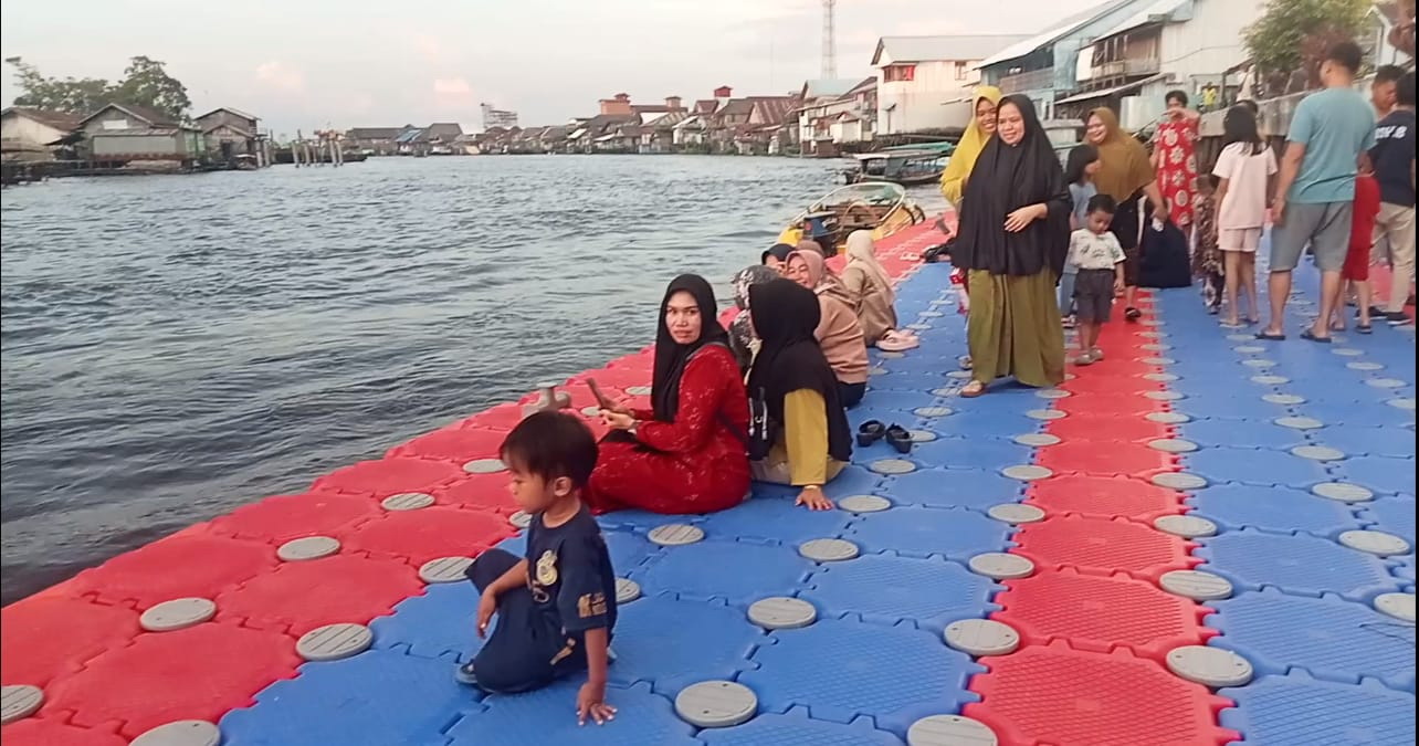 Sebuah dermaga apung disediakan di kawasan pelabuhan Pasar Inpres Sukamara dimanfaatkan warga untuk bersantai.