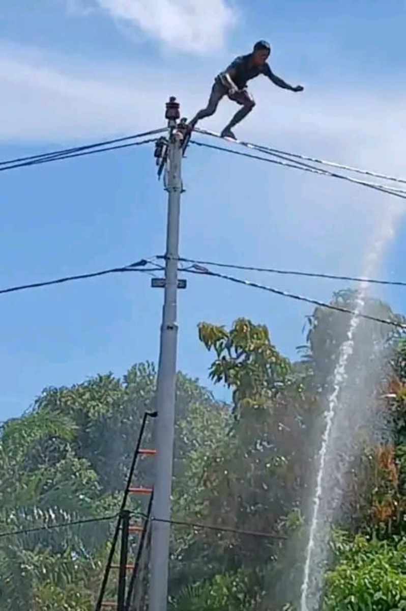 )  MELOMPAT: Aksi lompat dari tiang listrik yang dilakukan pria berinisial A di Desa Bajuh,Kapuas Tengah (Lihin/Radar Sampit)