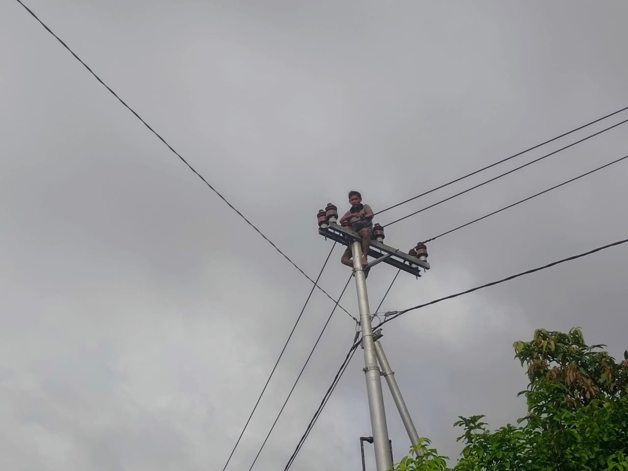 NAIK TIANG LISTRIK:&nbsp;Seorang pemuda di Desa Bajuh yang menaiki tiang listrik (Rahmadi/Radar Sampit)