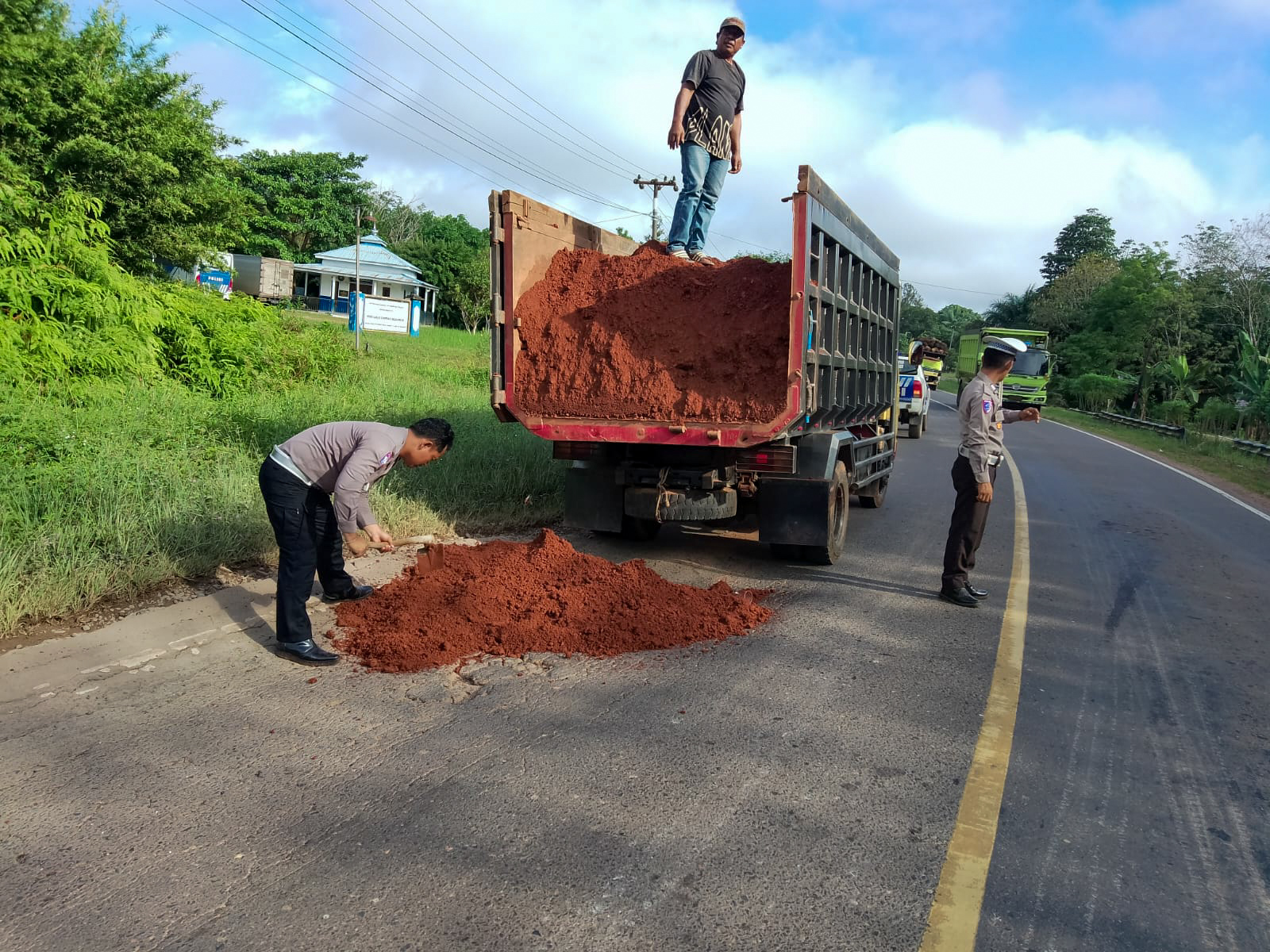 Personel Satlantas Polres Seruyan saat menutup lubang di jalan di kilometer 62 Sampit-Pangkalan Bun.