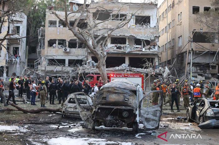 Pasukan keamanan dan penyelamat Israel bekerja di lokasi serangan rudal dari Iran di Tel Aviv, Israel, Senin (16/6).