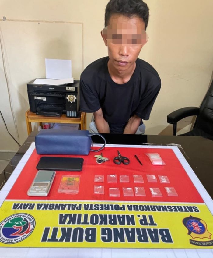 DIAMANKAN : Ahmad Rizal Rusadi alias Rizal bersama barang bukti narkoba diamankan di kantor polisi. //FOTO: POLRESTA PALANGKA RAYA/RADAR SAMPIT
