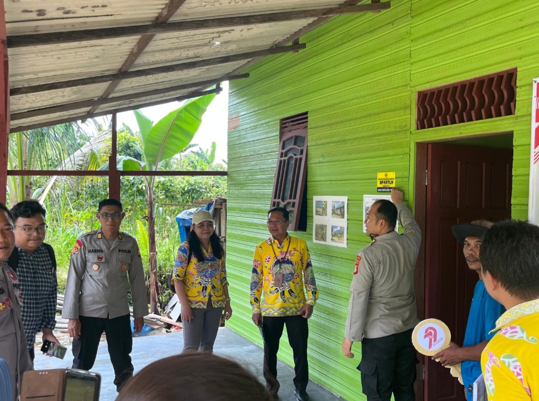 Pihak pemerintah dan Polres Gumas saat meninjau salah satu bangunan rumah yang sudah selesai dibedah.