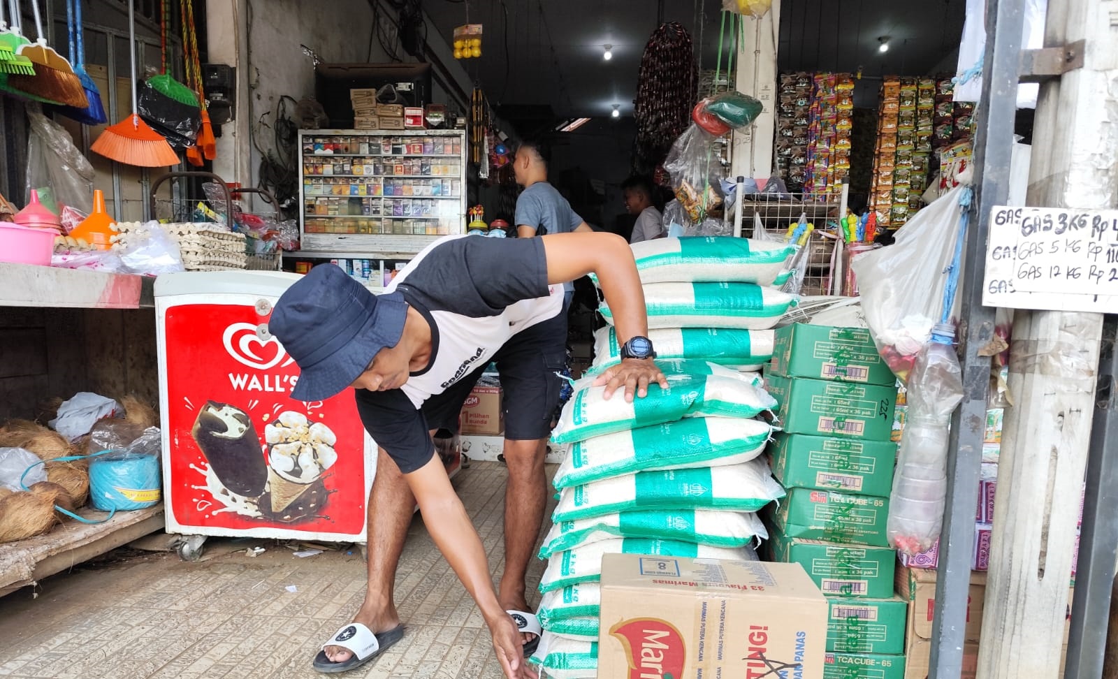 Penjual sedang menyusun salah satu jenis beras lokal kemasan yang dijual di beberapa warung sembako di Sampit, Sabtu (5/7).