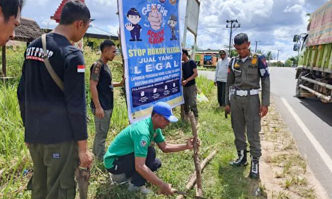 Petugas Satpol PP Seruyan saat memasang baliho sosialisasi pajak rokok dan pemberantasan rokok ilegal di Simpang Terawan, Kecamatan Seruyan Raya, Jumat (11/7).