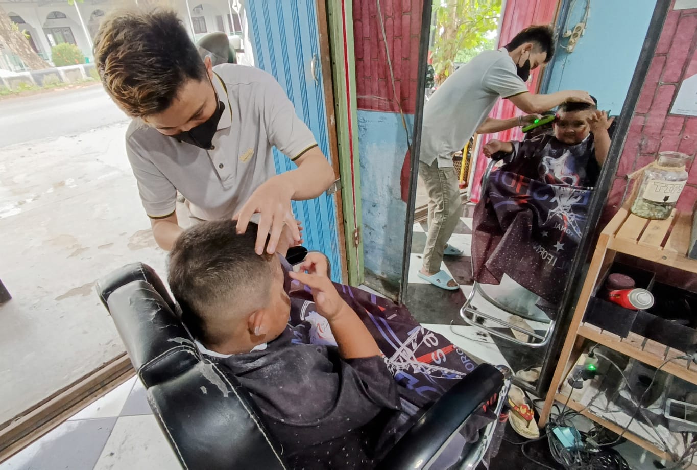 Salah satu barbershop atau tempat pangkas rambut melayani seorang anak dengan permintaan gaya rambut mirip bintang sepak bola. (Usay Nor Rahmad for Radar Sampit)