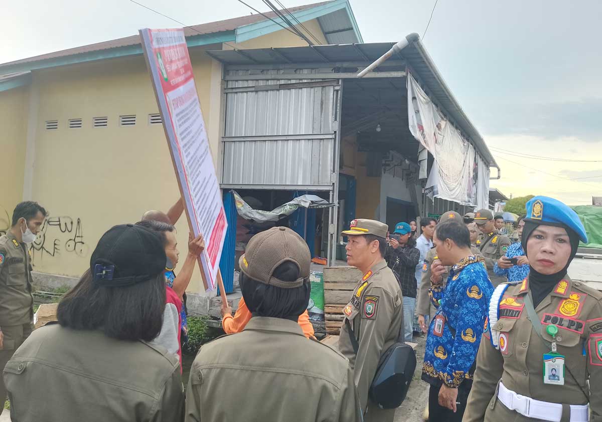 PEMBERITAHUAN: Satpol PP Kotim saat memasang papan pemberitahuan di Jalan Sukabumi, Kamis (17/7).