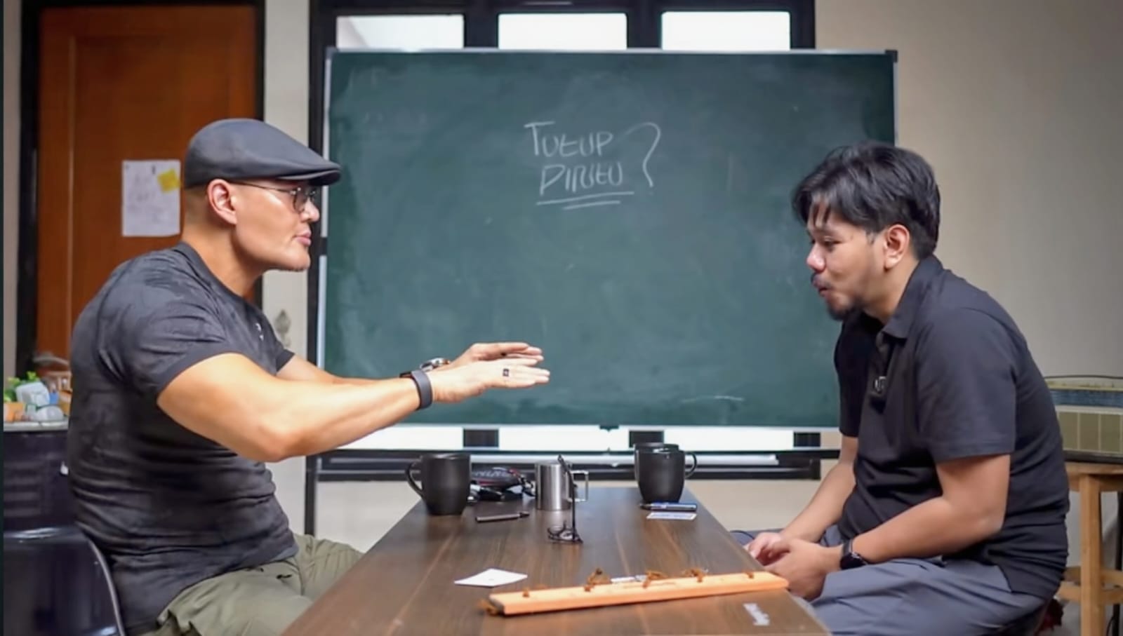 Tangkapan layar Deddy Corbuzier mempraktikan teknik pertunjukan yang disebut telekinesis dengan menggerakkan kacamata tanpa menyentuh di depan Ferry Irawandi. (Youtube: Ferry Irawandi)