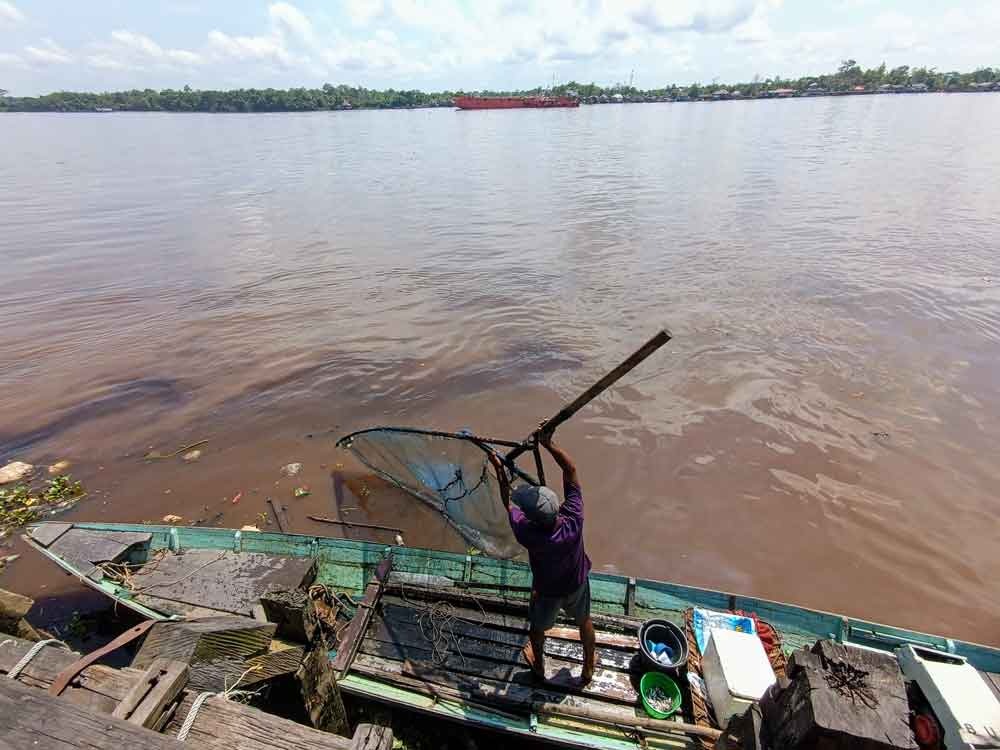 Seorang nelayan tangkap menjaring ikan di tengah kondisi air Sungai Mentaya yang kotor. (Dokumentasi Usay Nor Rahmad untuk Radar Sampit)