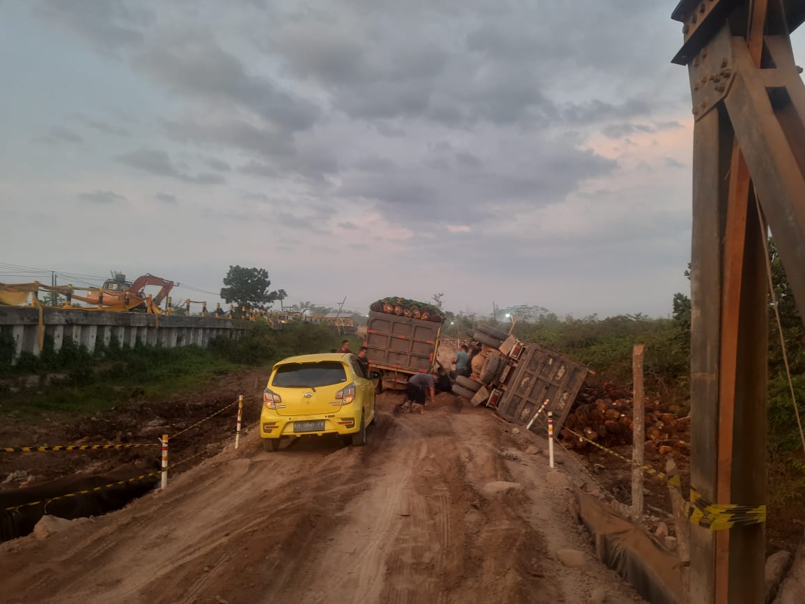 TERGULING: Truk bermuatan kelapa sawit terguling di jalur alternatif Jmebatan Sei Lenggana, Jumat (1/8/2025) (Gunawan/Radar Sampit)