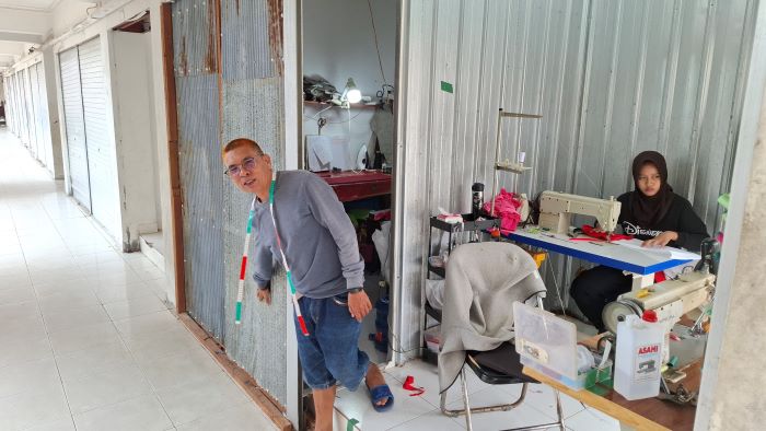 PERCOBAAN PENCURIAN : Amat memperlihatkan kios miliknya yang rusak akibat hendak dibobol maling di Pasar Eks Mentaya Sampit, Senin (4/8/2025). FAHRY/RADAR SAMPIT