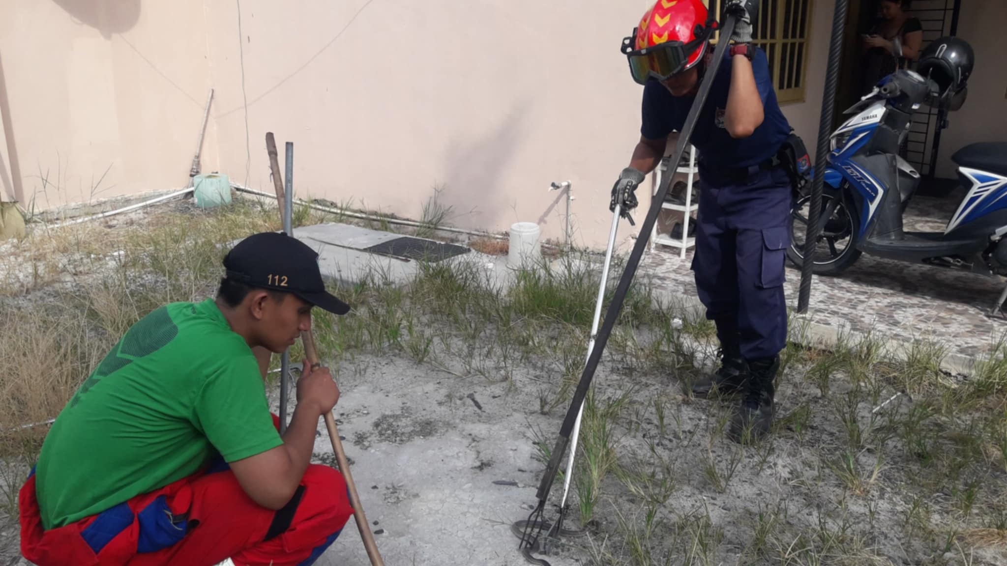 Anggota Tim Rescue Damkar Palangka Raya saaat melakukan evakuasi terhadap seekor ular berbisa di kawasan Jalan Jati Raya II, Selasa (5/8).