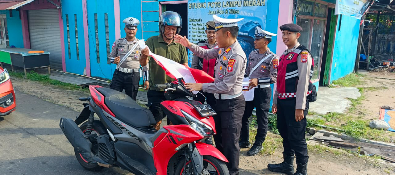 HUT RI : Personel Satlantas Polres Seruyan membagikan 100 bendera kepada penguna jalan di kawasan traffic light Kuala Pembuang, Rabu (6/8/2025). FOTO: POLRES SERUYAN/RADAR SAMPIT