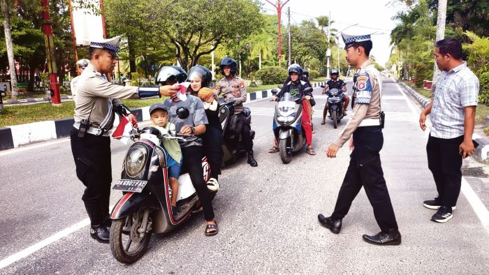 SEMARAK HUT RI : Satlantas Polresta Palangka Raya membagikan bendera Merah Putih gratis kepada pengguna jalan, Rabu (6/8/2025). FOTO: NURDIN HIDAYAT/RADAR SAMPIT