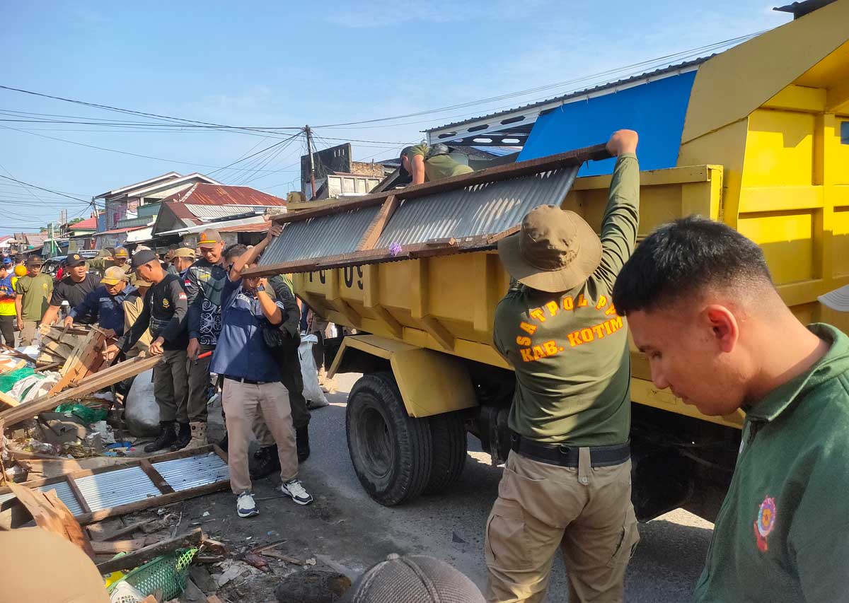 GOTONG ROYONG: Petugas membersihkan sisa puing-puing bangunan lapak pedagang pascapenertiban pekan lalu, Selasa (5/8).&nbsp;