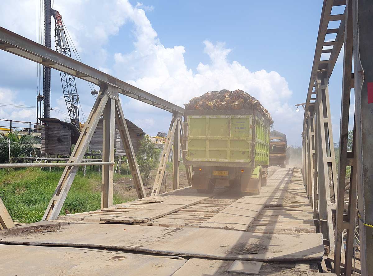 TETAP MELINTAS: Truk yang mengangkut TBS kelapa sawit saat melintas di jembatan darurat Sei Lenggana, Rabu (6/8) lalu.