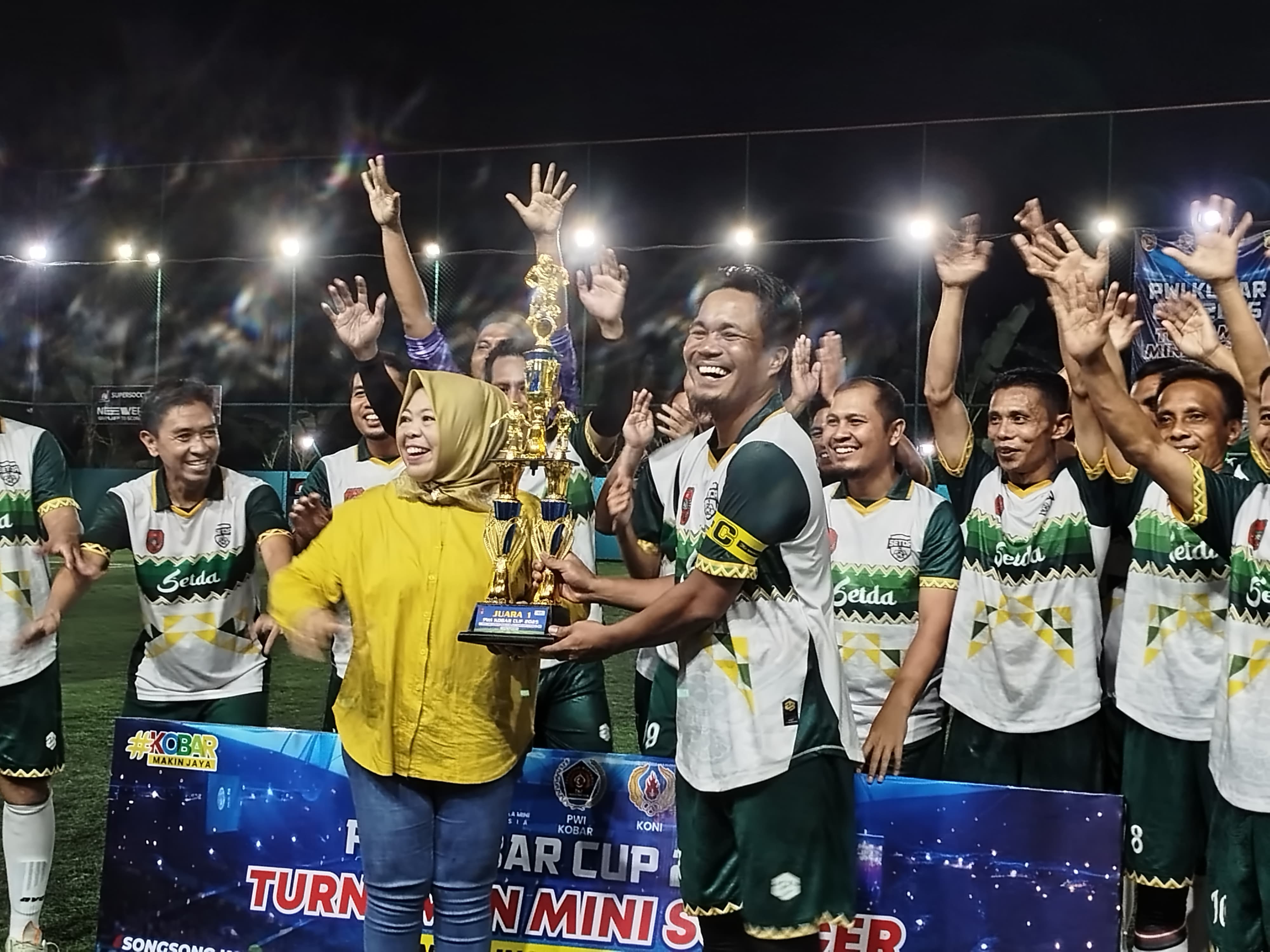 JUARA: Bupati Kobar Hj Nurhidayah saat menyerahkan trofi juara Turnamen Minisoccer PWI Kobar Cup kepada Tim Setda FC, Minggu (10/8/2025) (Istimewa/Yusro/Radar Sampit)
