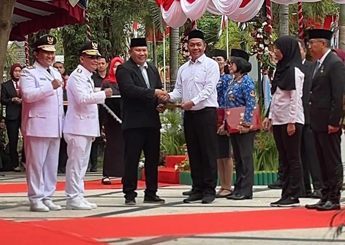 SIMBOLIS: Kepala Kanwil Ditjenpas Kalteng I Putu Murdiana menyerahkan surat keputusan remisi kepada perwakilan warga binaan, Minggu (17/8).