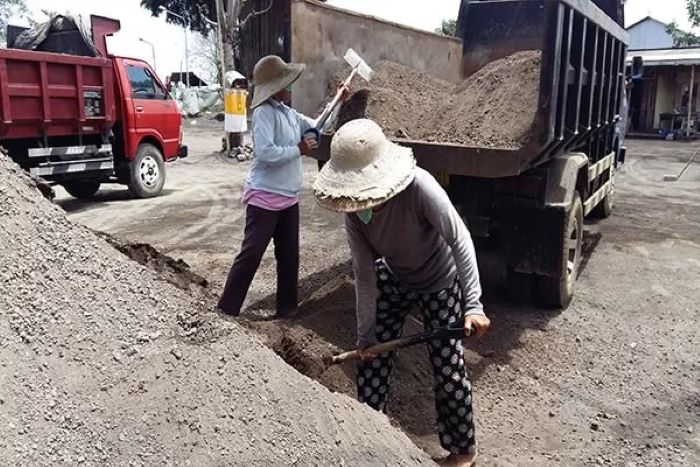 ILUSTRASI: Pekerja memasukan pasir ke dalam bak truk. FOTO: JAWAPOS/RADAR BALI