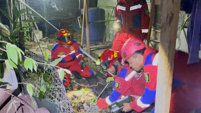 PENANGANAN : Tim Rescue Damkar Kota Palangka Raya saat melakukan penanganan ular piton sepanjang tiga meter dari kawasan pemukiman warga di Jalan Jalak, Rajawali, Kamis (28/8/2025) malam. FOTO: DAMKAR
