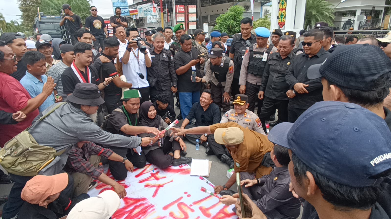 Pendemo memberikan bunga untuk disampaikan ke Bupati Kotim Halikinnor usai menandatangani berita acara dan poin tuntutan demo, di depan Gedung DPRD Kotim, Senin (1/9/2025). (Oes/Radar Sampit