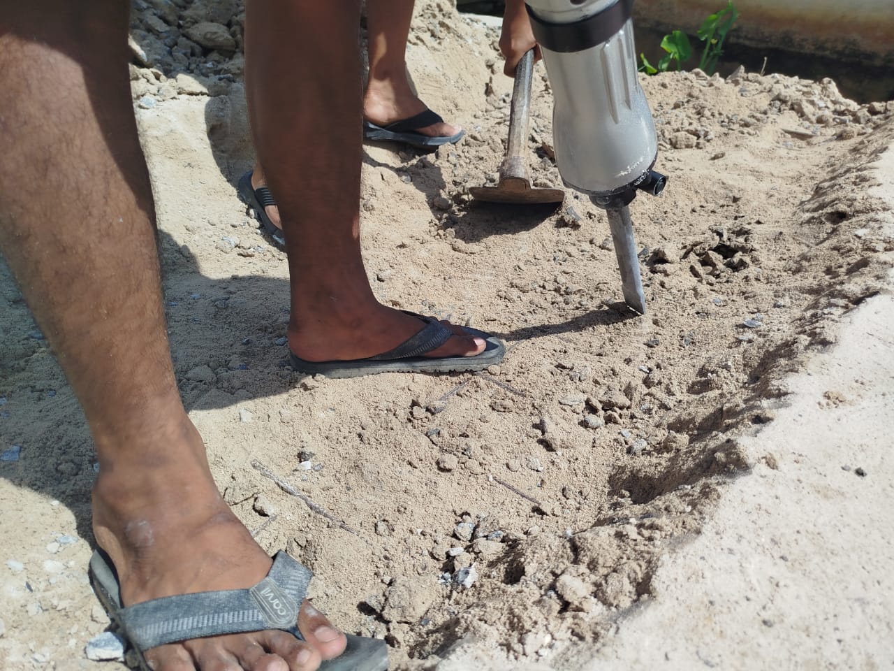 DIPERBAIKI: Tukang proyek jalan sedang memperbaiki cor beton jalan yang retak.