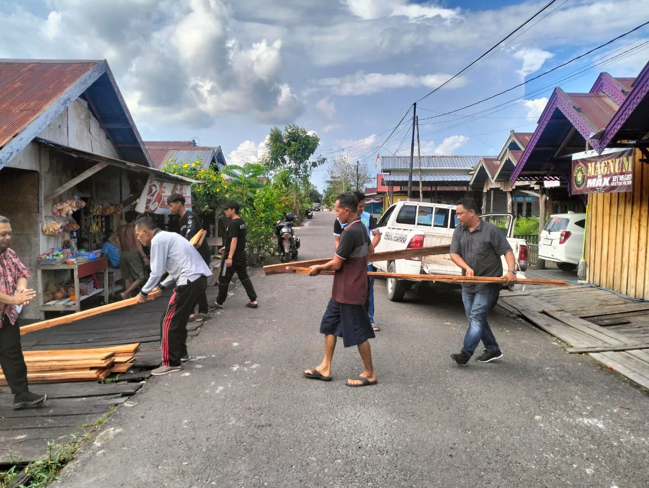 Penyaluran  bantuan papan dan kayu cerucuk, untuk membantu warga yang rumahnya terendam banjir di wilayah Kecamatan Sukamara.