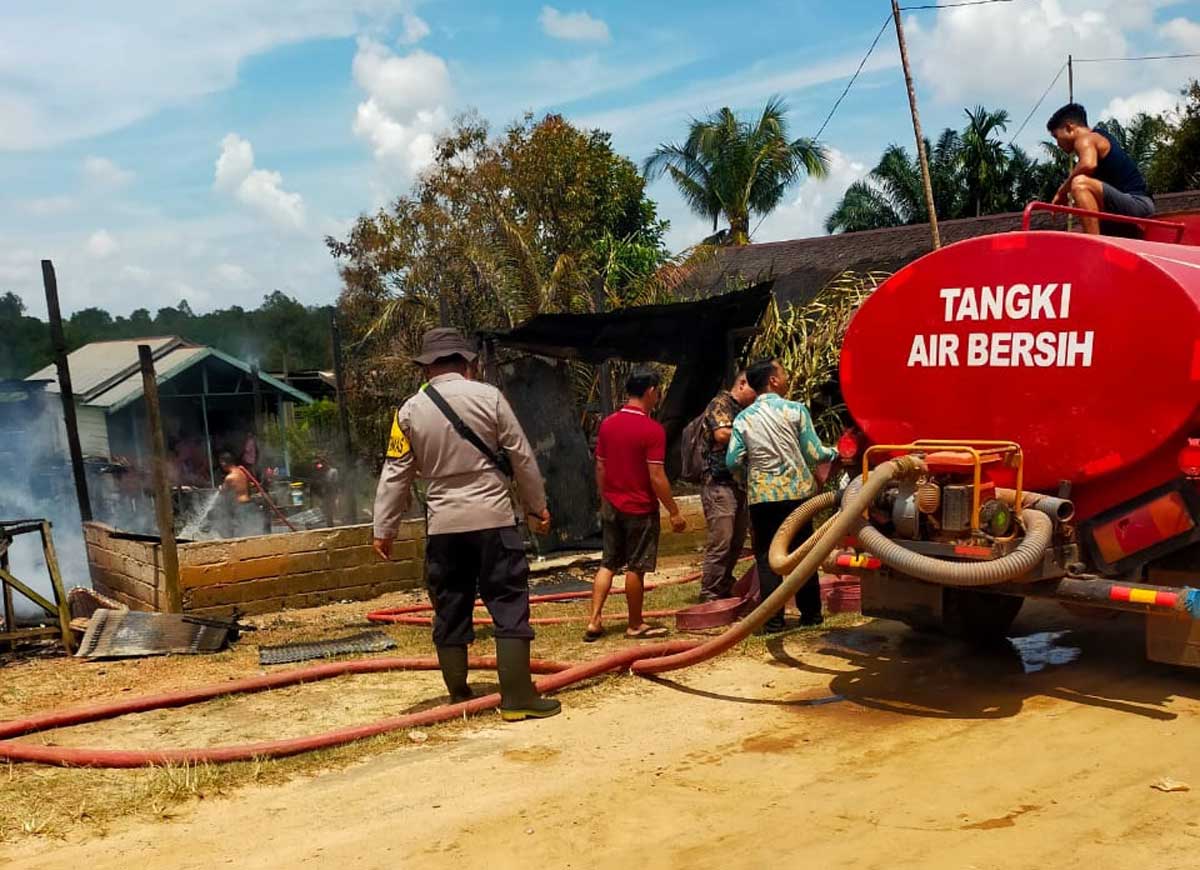 PEMADAMAN: Petugas Polri dan pemadam berjibaku memadamkan api di Desa Tanah Putih, Telawang, Minggu (21/9).