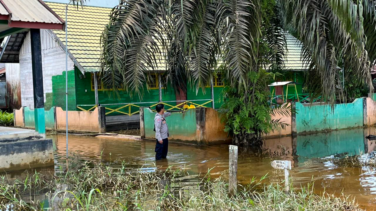 Anggota Polsek Hanau memantau debit air Sungai Seruyan yang mulai surut, Kamis (25/9).