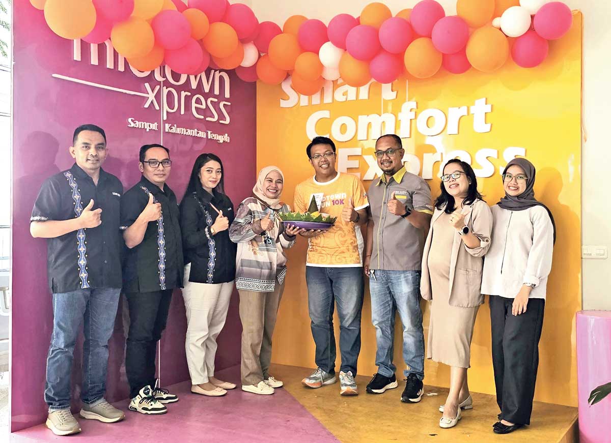 PERERAT KEMITRAAN: Direktur Radar Sampit Siti Fauziah menyerahkan tumpeng pada Anniversary 10 Tahun Midtown Xpress Sampit, Senin (29/9).